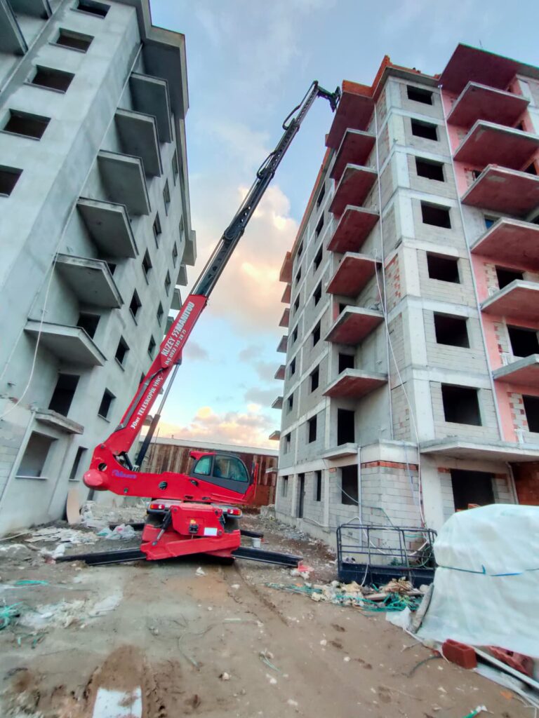 İki bina arasındaki dar alanda manevra yapabilen 30 metre erişimli kiralık Manitou.