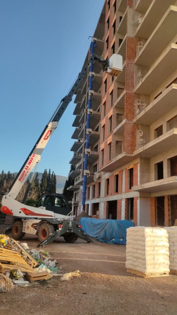 Kuzey 55 İnşaat güvencesiyle İzmir'de Ytong ve tuğla paletlerini üst katlara güvenle taşıyan telehandler vinç.