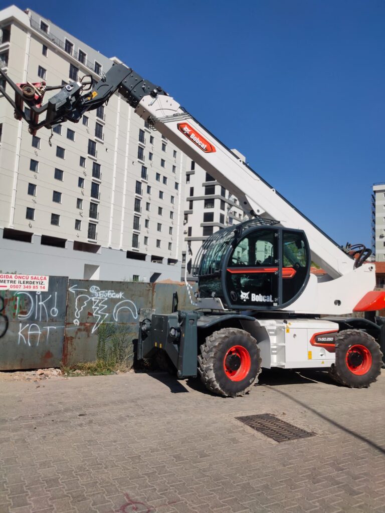 Kuzey 55 İnşaat makine parkında bulunan, döner ataşmanlı beyaz Bobcat telehandler iş makinesi.