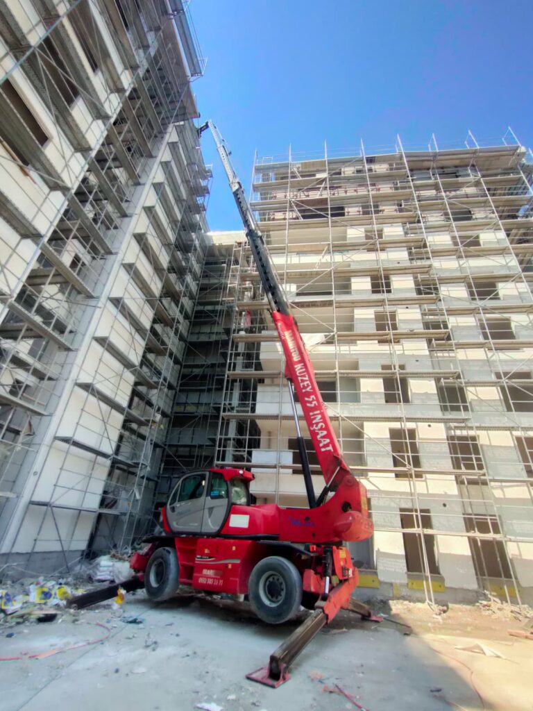 Yüksek katlı binada dış cephe mantolama ve iskele çalışmalarına malzeme desteği sağlayan Kuzey 55 Manitou vinç.