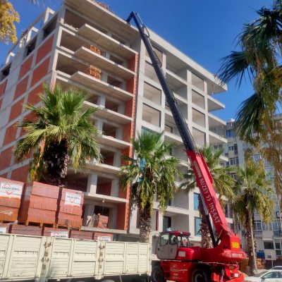 İzmir'de yüksek katlı bina inşaatına Manitou vinç kullanarak tuğla ve çatı malzemesi çıkarma hizmeti.