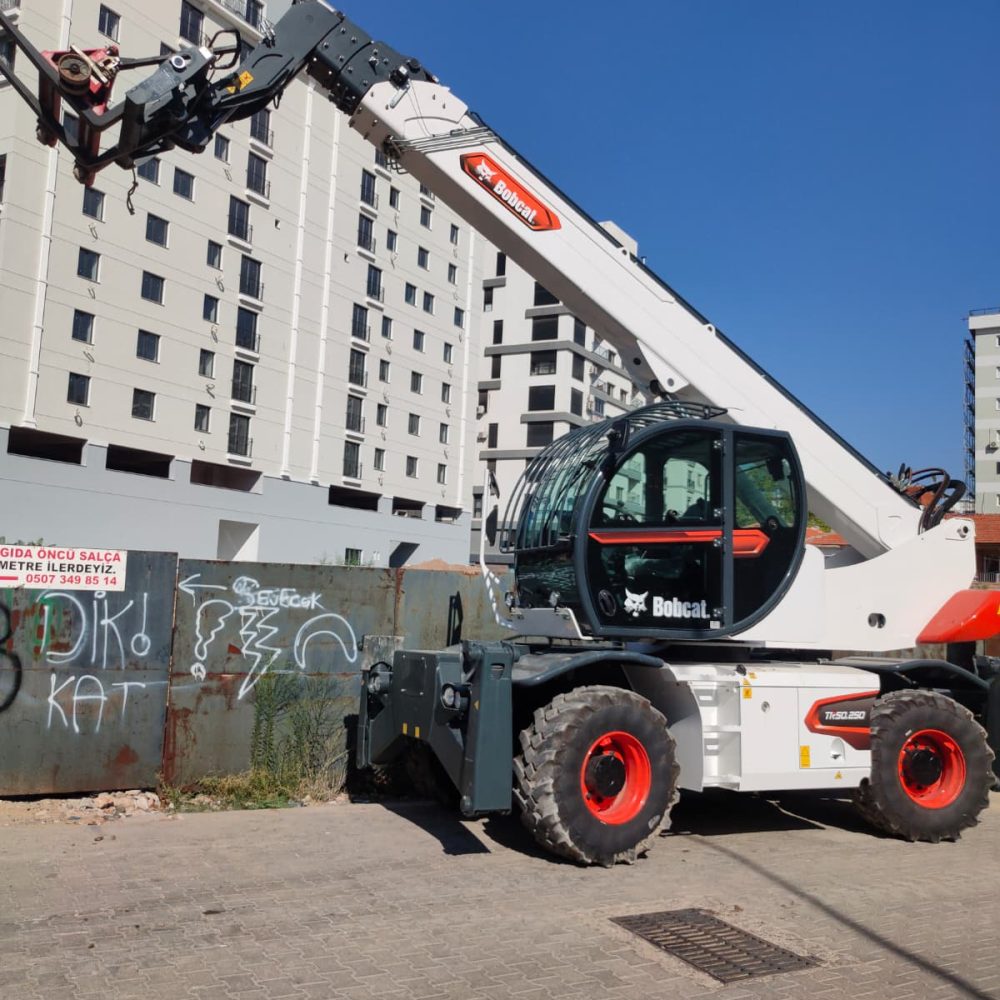 Kuzey 55 İnşaat makine parkında bulunan, döner ataşmanlı beyaz Bobcat telehandler iş makinesi.